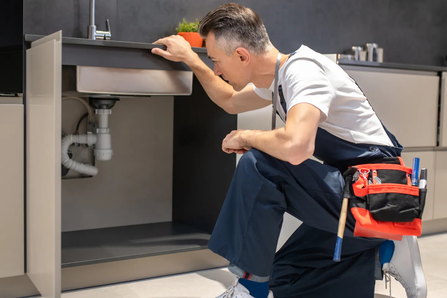 Modern plumbing website featuring a plumber inspecting under-sink piping